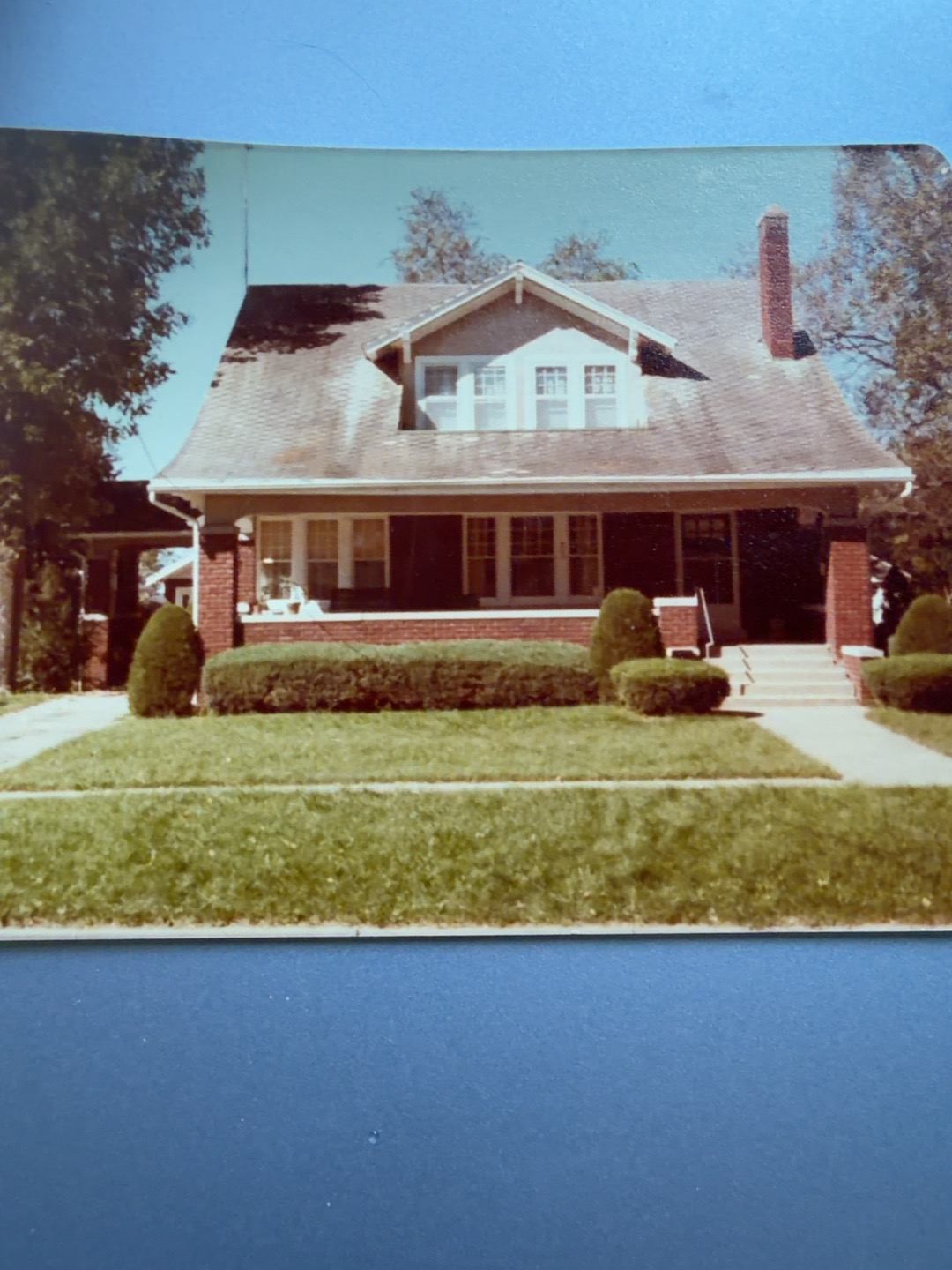Joe and Ida Roling’s brick home on LeFevre Street in Salisbury, Missouri, with a front porch, dormer, chimney and hedges.