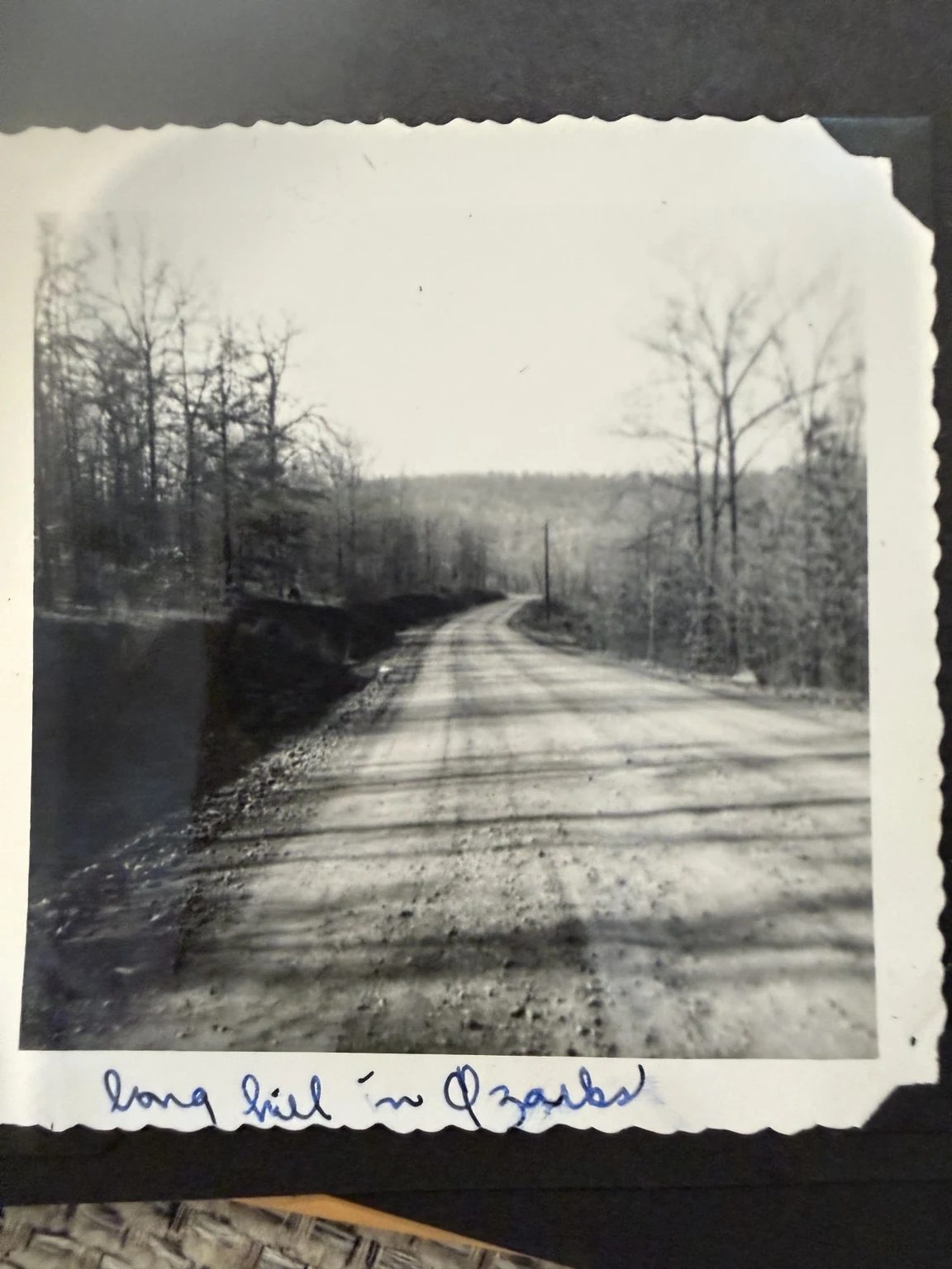 “long hill in Ozarks” (original caption). A road crossing wooded hills. Exact route and date are unconfirmed.