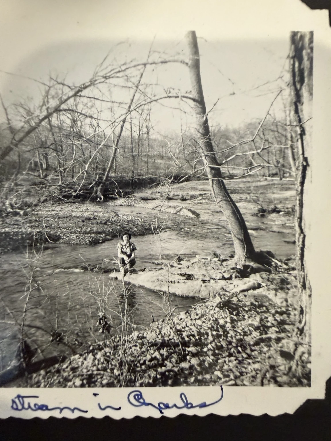 “Stream in Ozarks” (original caption). The family collection identifies the person as Bridget. Exact waterway and date are unconfirmed.