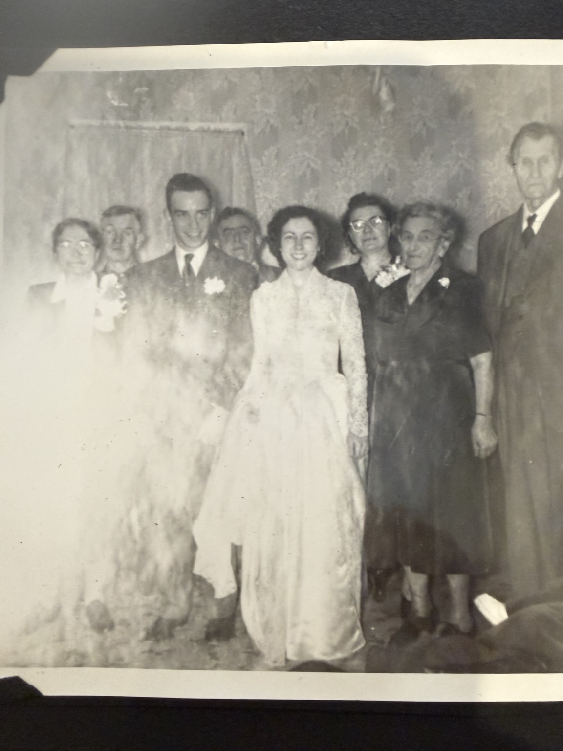 A group posed indoors against patterned wallpaper.