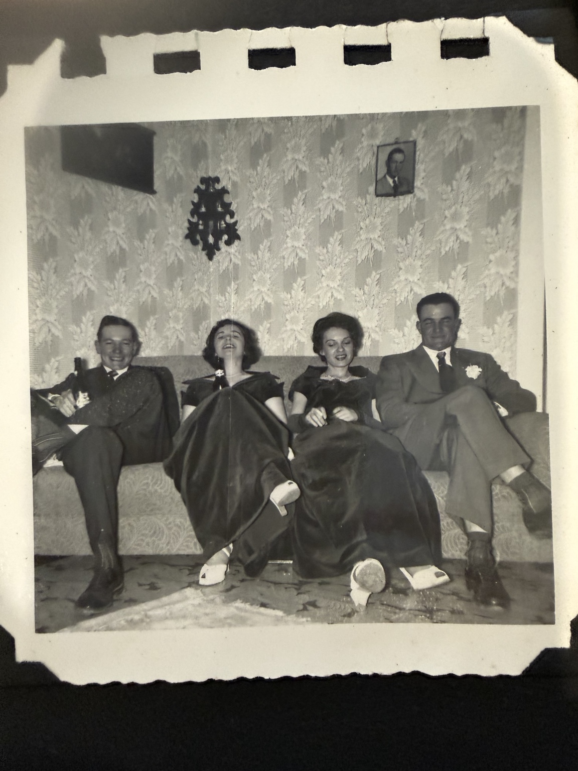 Four people seated together on a sofa.