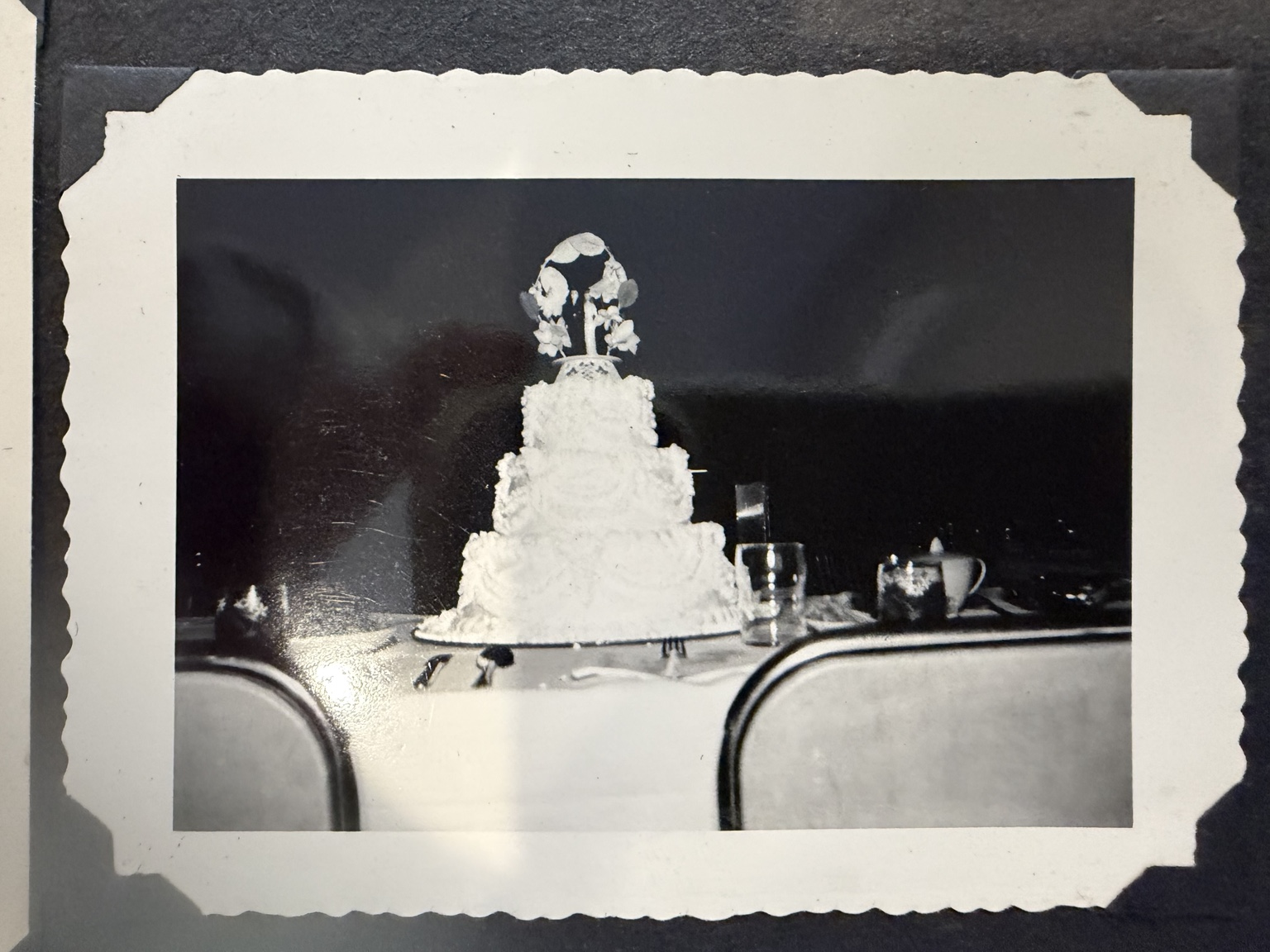 A tiered wedding cake with a couple figurine on top.