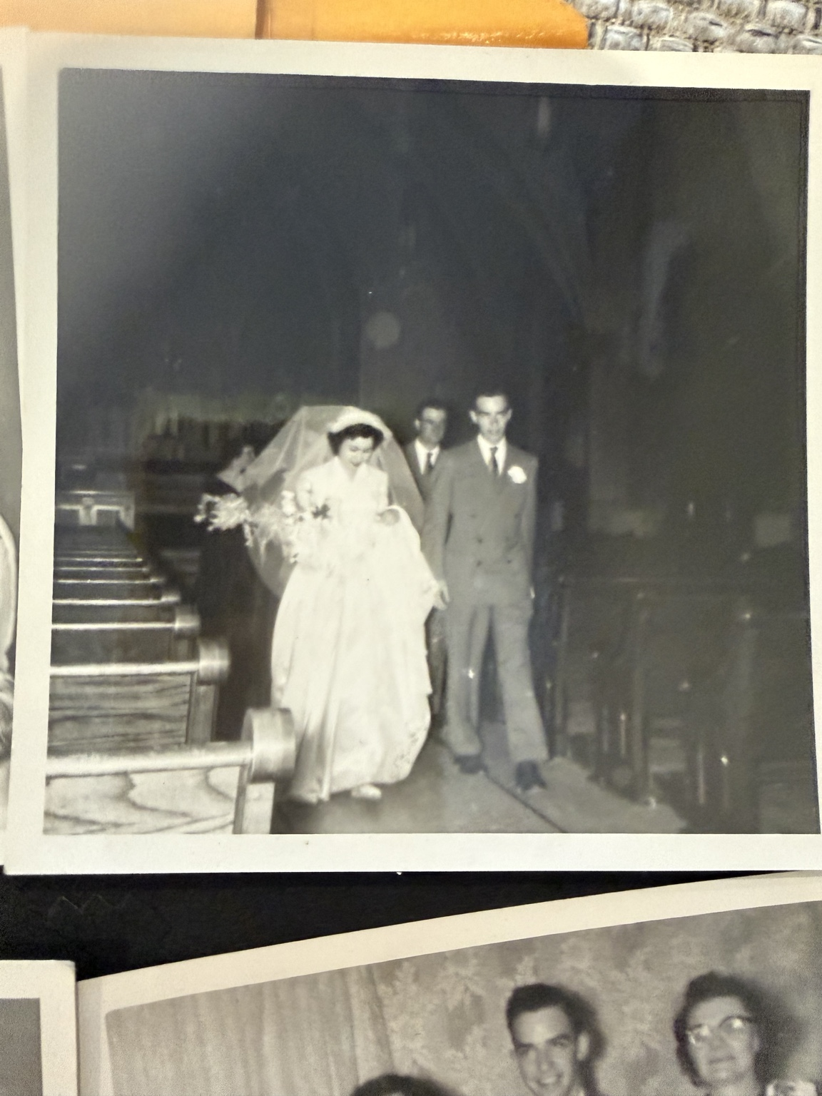 Bride and groom with other wedding-party members near the front of the church aisle.
