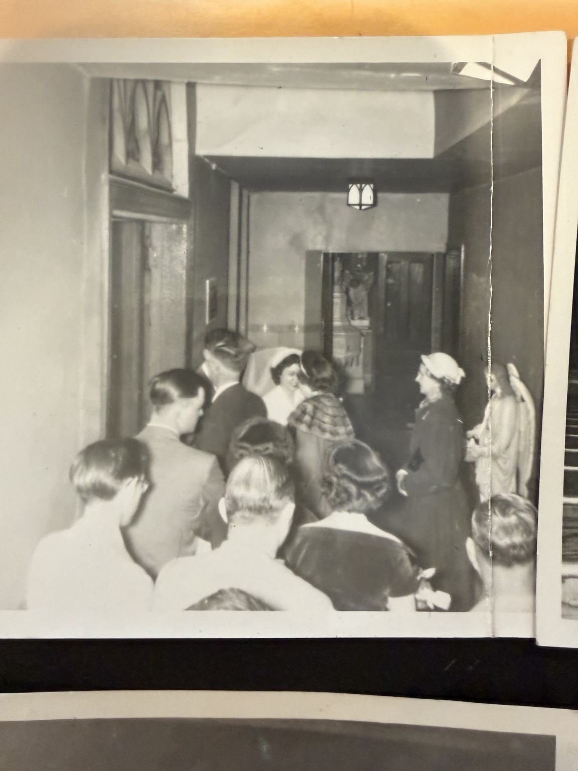 A group gathered near a doorway, seen from behind in a narrow interior.