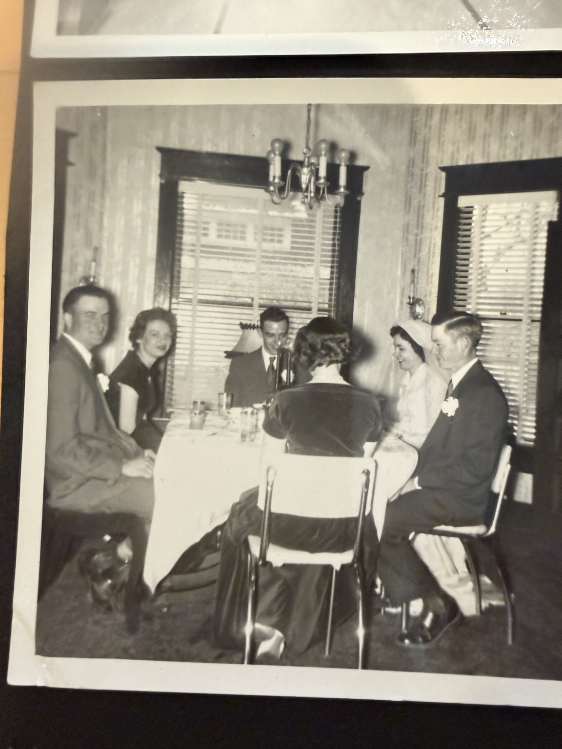 People seated around a table beneath a chandelier.