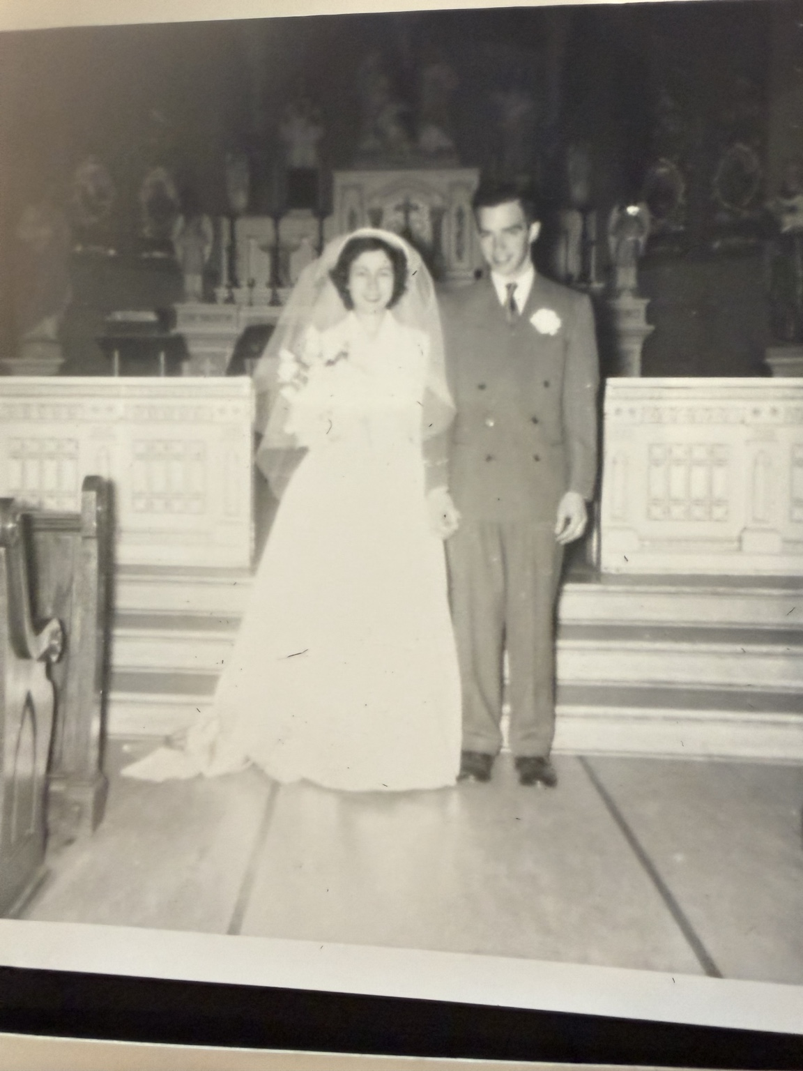 Bride and groom posed together in front of the altar.